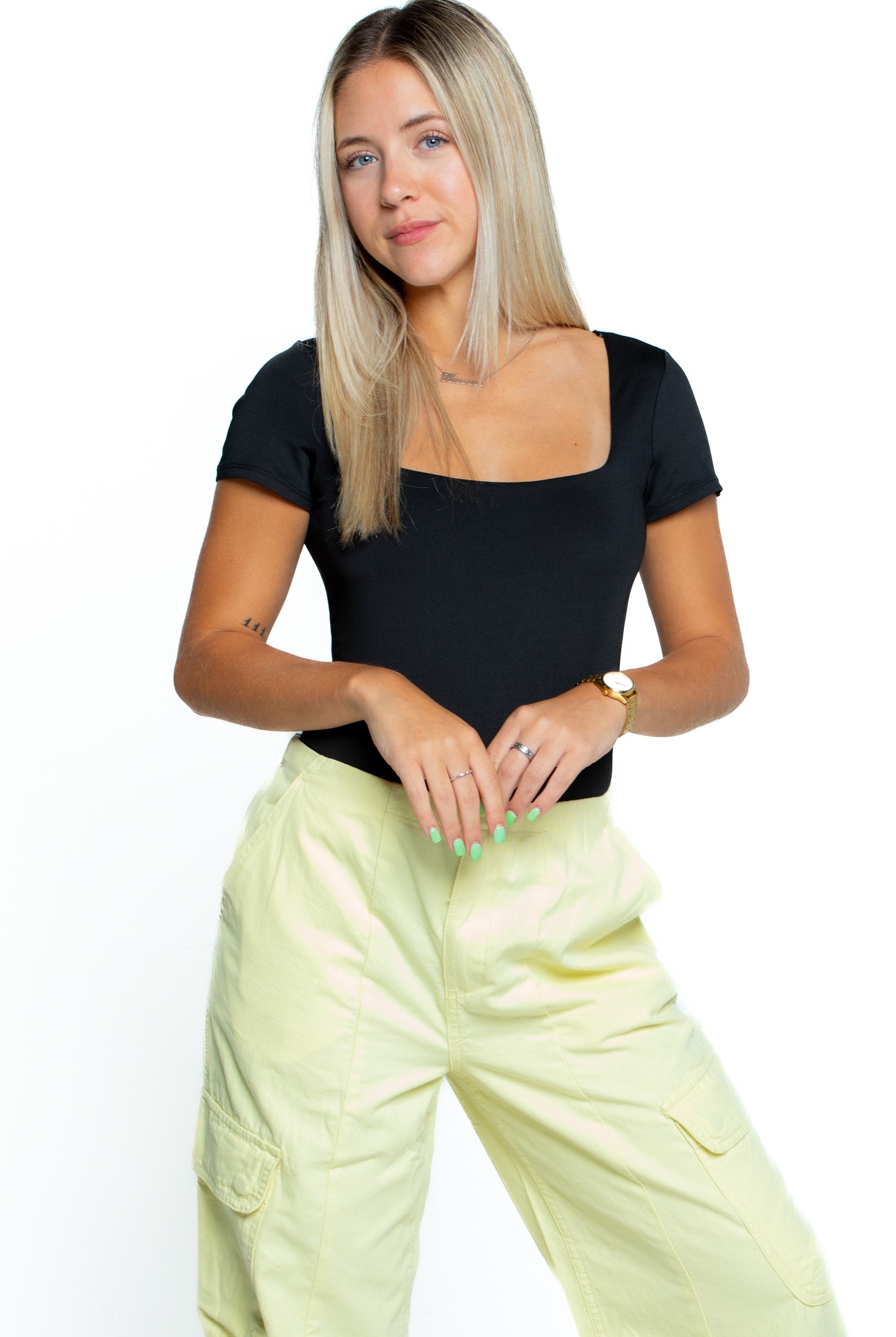 A fashionable women wearing black crop top and slim fit cargo jogger